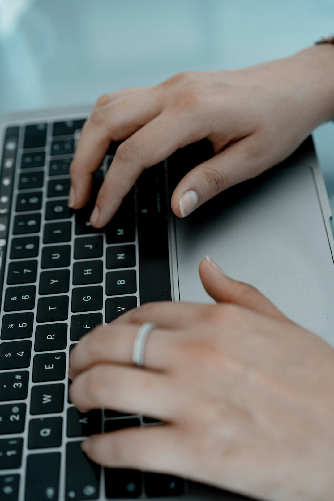 person-wearing-silver-ring-on-macbook-pro.jpg person wearing silver ring on macbook pro